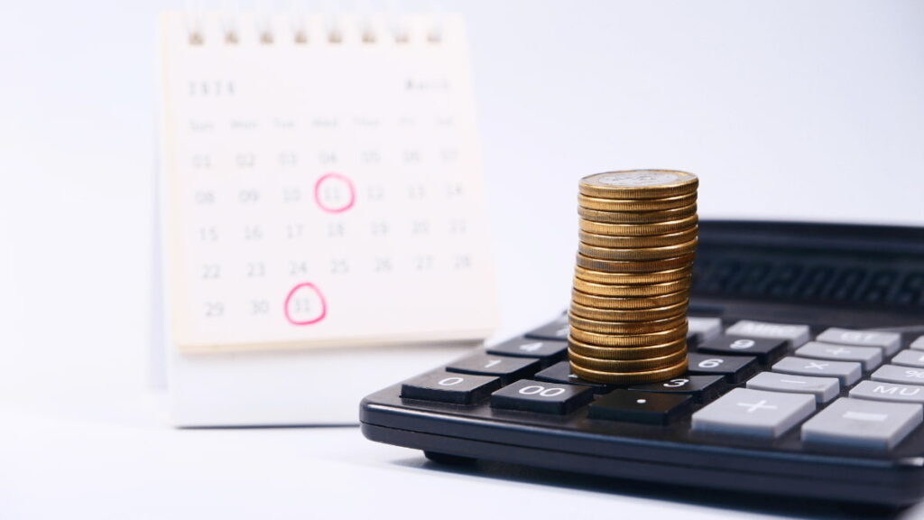 Uma pilha de moedas em cima de uma calculadora