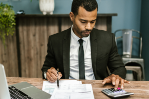 Advogado autônomo em seu escritório calculando tributos a serem pagos