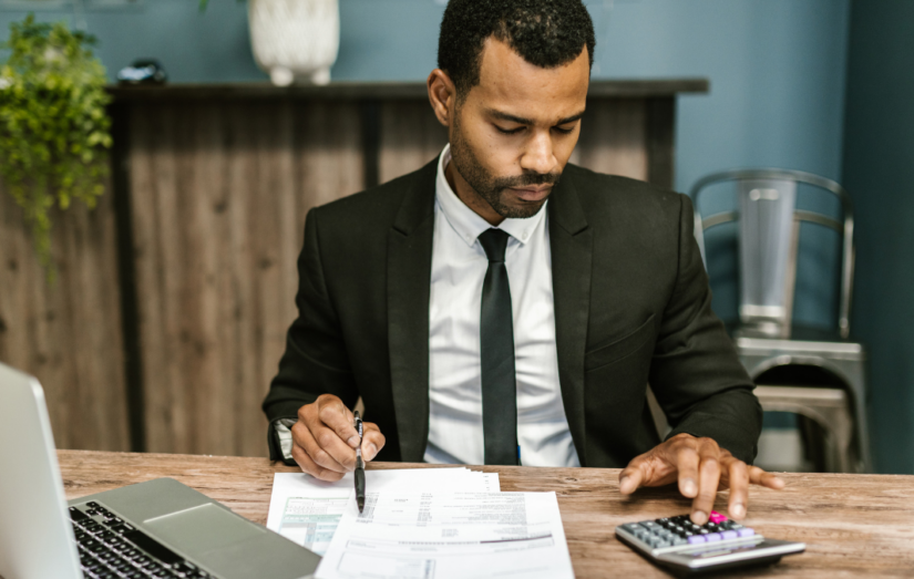 Advogado autônomo em seu escritório calculando tributos a serem pagos