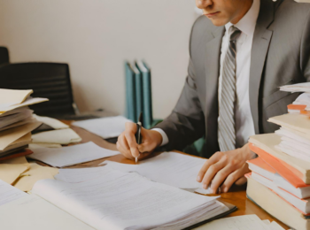 advogado sobrecarregado de trabalho com a mesa cheia de processos