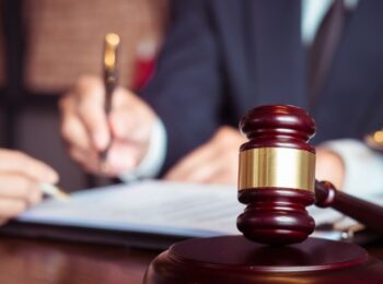 Cessão de honorários advocatícios sendo formalizada, com martelo de juiz em destaque simbolizando justiça e contratos jurídicos.